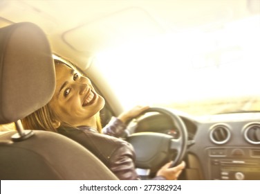 Woman In Car Indoor Keeps Wheel Turning Around Smiling Looking At Passengers In Back Seat Idea Taxi Driver Talking To Police Companion Companion Who Asks For Directions Right To Drive Documents Exam