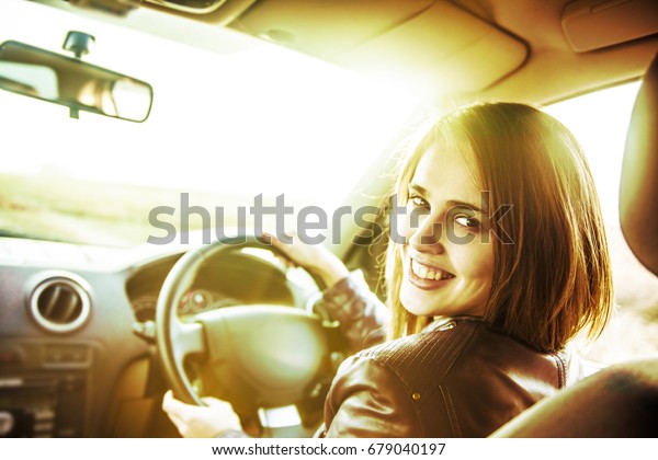 woman in car indoor keeps wheel turning
around smiling looking at passengers in back seat idea taxi driver
talking to police companion companion who asks for directions right
to drive Documents exam