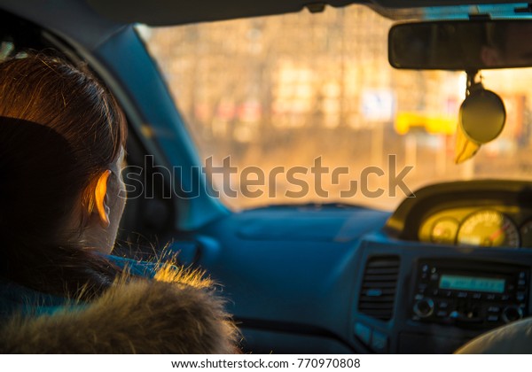 woman in car indoor sit near\
driver at passengers seat.  idea taxi driver against sunset rays.\
Light shine on street. Concept of exam Vehicle - second home the\
girl