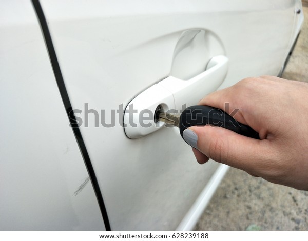 Woman with car key. Opening car door. Women´s hand\
unlock a door on a car.