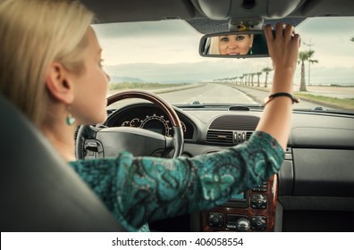 Woman In Car Look In Rear View Mirror