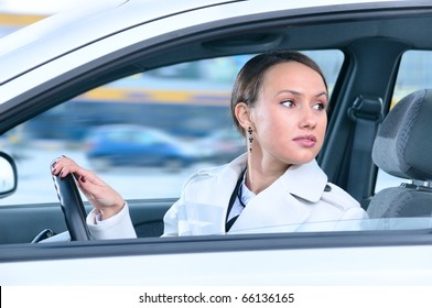 Woman In A Car Is Looking Backwards Trying To Move Back