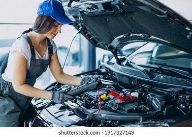 Woman car mechanic checking vehicle and engine