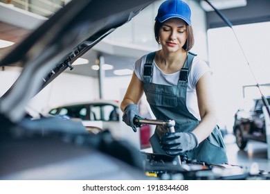 Woman car mechanic checking vehicle and engine - Powered by Shutterstock