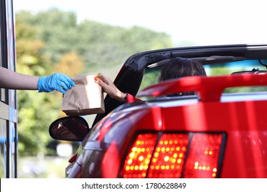 Woman In Car Picks Up Bag Of Food Closeup. Fast Food Concept