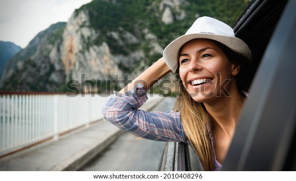 Woman in
car road trip waving out the window
smiling