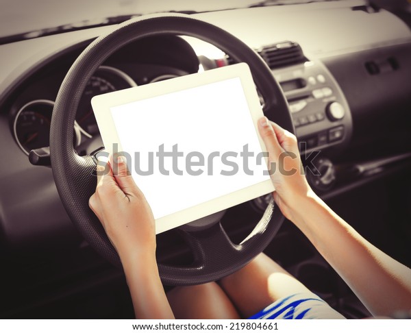Woman in the\
car with tablet pc. Vintage\
photo.