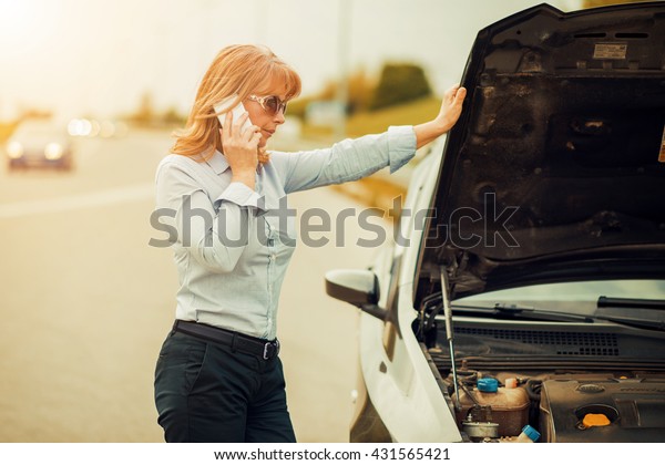 Woman with car trouble in the middle of the\
street,after car\
breakdown.