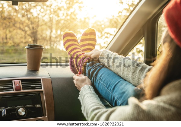 Woman in a car in warm woolen yellow socks on the\
car dashboard. Cozy autumn weekend trip. The concept of freedom of\
travel