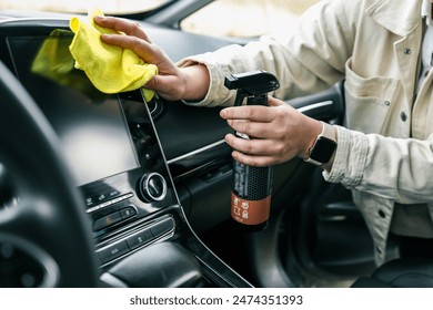 A woman at a car wash does a full dry-cleaning of all parts of a car using special chemistry, cloths, sponges and brushes. Concept of: Full car cleaning, Dry cleaning, Professional service. Car, Work. - Powered by Shutterstock