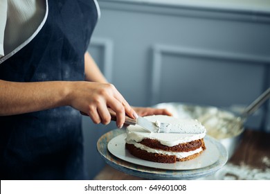 Woman Carefully Icing The Cake And Decorating