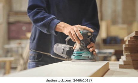 Woman carpenter sanding wood block. Girl process timber bar close up. Male carpentry work skill. Female joiner woodwork. Guy worker. Person man use sander tool. Diy master class workshop. Job project. - Powered by Shutterstock