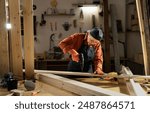 Woman Carpenter working with drill at carpentry workshop. Copy space