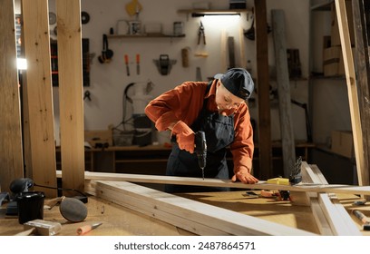 Woman Carpenter working with drill at carpentry workshop. Copy space - Powered by Shutterstock