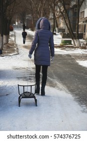 Woman Carries Empty Sled