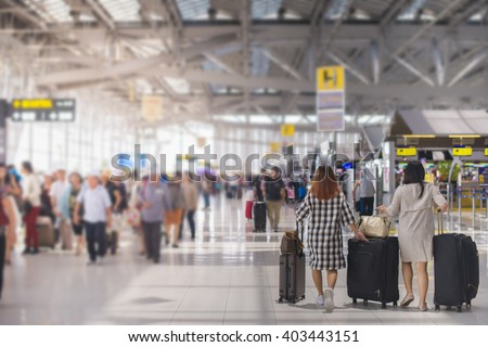 woman carries luggage at the airport terminal.