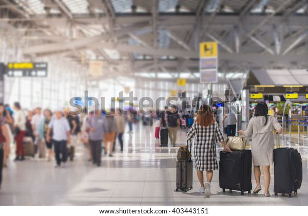 woman carries\
luggage at the airport\
terminal.