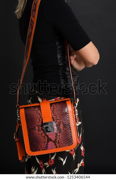 Woman carring  orange handmade handbag made from
python skin