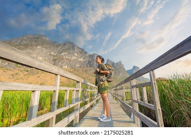 woman carrying a backpack hiking on vacation,woman carrying a backpack traveling in the mountains,Horizontal view of unrecognizable woman on top of mountain. Travel and holidays concept in summer.