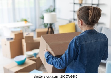 Woman Carrying Boxes In Her New Apartment, Home Relocation Concept