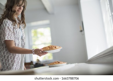 A Woman Carrying Food To A Table, Preparing For A Family Meal.