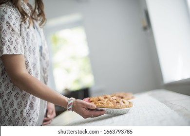 A Woman Carrying Food To A Table, Preparing For A Family Meal.