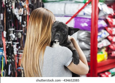 Woman Carrying French Bulldog At Pet Store