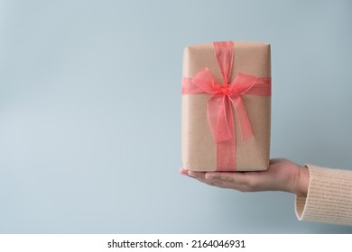 Woman Carrying Gift Paper Box Tie Cute Ribbon For Special Occasion. Delivery Sending Present To Someone Special To Thank Or Surprise.