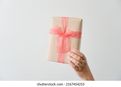 Woman Carrying Gift Paper Box Tie Cute Ribbon For Special Occasion. Delivery Sending Present To Someone Special To Thank Or Surprise.