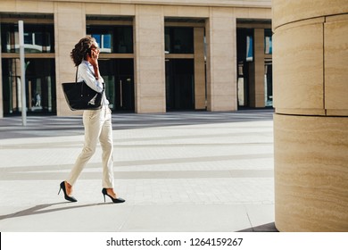 Woman Carrying Handbag On Shoulder Walking On City Street From Office