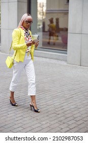 Woman Carrying Laptop And Notepad Walking Down The Street