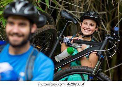 Woman carrying mountain bike in forest - Powered by Shutterstock