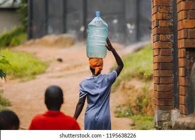 Woman Carrying Water Can In Uganda, Africa