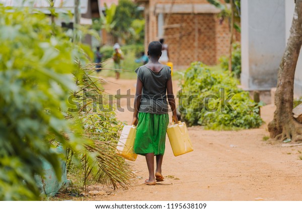 Ugandan Girl Carries Jerry Can On A Dirt Path Editorial 
