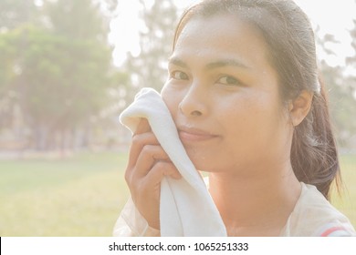 Woman carrying a white towel, drops of mineral water. spray on the face In the morning nature