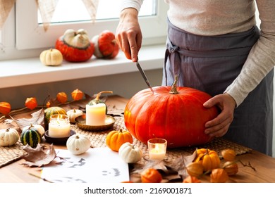 Woman Carves A Pumpkin For Handmade Jack-O-lantern At Home For Halloween Party Decoration. Concept Of Holiday Seasonal Handmade Decor. Autumn Colors, Faceless, Close-up