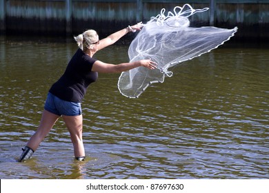 Woman Casting Net For Bait To Be Used For Surf Fishing