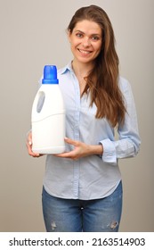 Woman In Casual Clothes Blue Shirt And Jeans Holding Laundry Detergent In White Big Bottle.