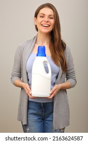 Woman In Casual Clothes Blue Shirt And Jeans Holding Laundry Detergent In White Big Bottle.