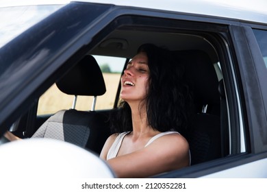 Woman In Casual Clothes Looking Over Shoulder While Driving Car