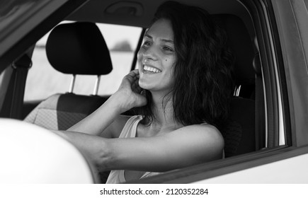 Woman In Casual Clothes Looking Over Shoulder While Driving Car