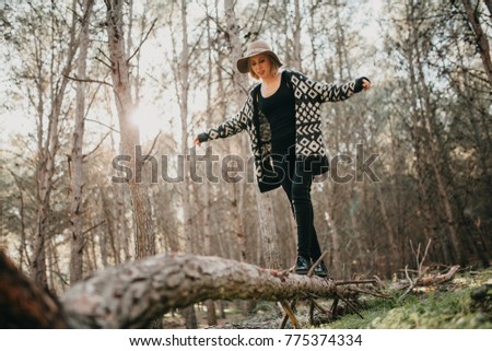 Woman walking on a fallen tree trunk