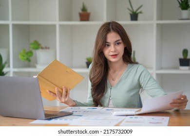 Woman In Casual Clothing Holding Note Book And Working On Laptop Computer 