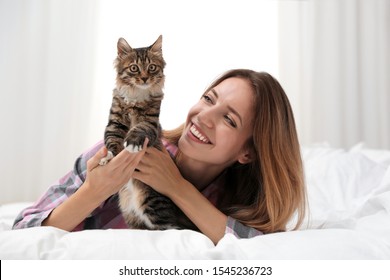 Woman With Cat In Bedroom. Owner And Pet