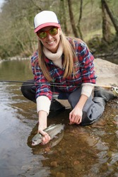 Woman Catching Rainbow Trout Fly In River