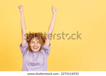 Woman celebrating while raising the arms and smiling