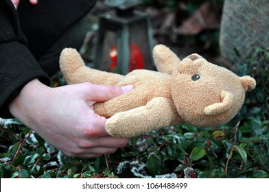 Woman In Cemetery In Deep Sadness About Death And Loss Puts A Teddy To Grave Of Her Child