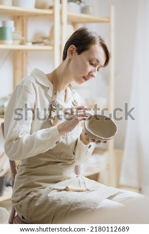 Similar – Image, Stock Photo Young female sitting by table and making clay or ceramic mug