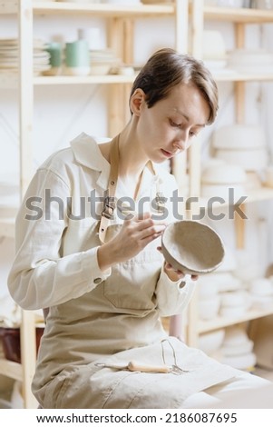 Similar – Image, Stock Photo Young female sitting by table and making clay or ceramic mug