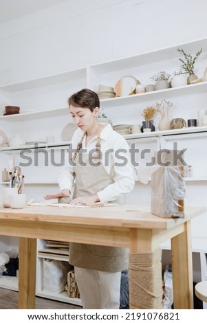 Similar – Image, Stock Photo Young female sitting by table and making clay or ceramic mug